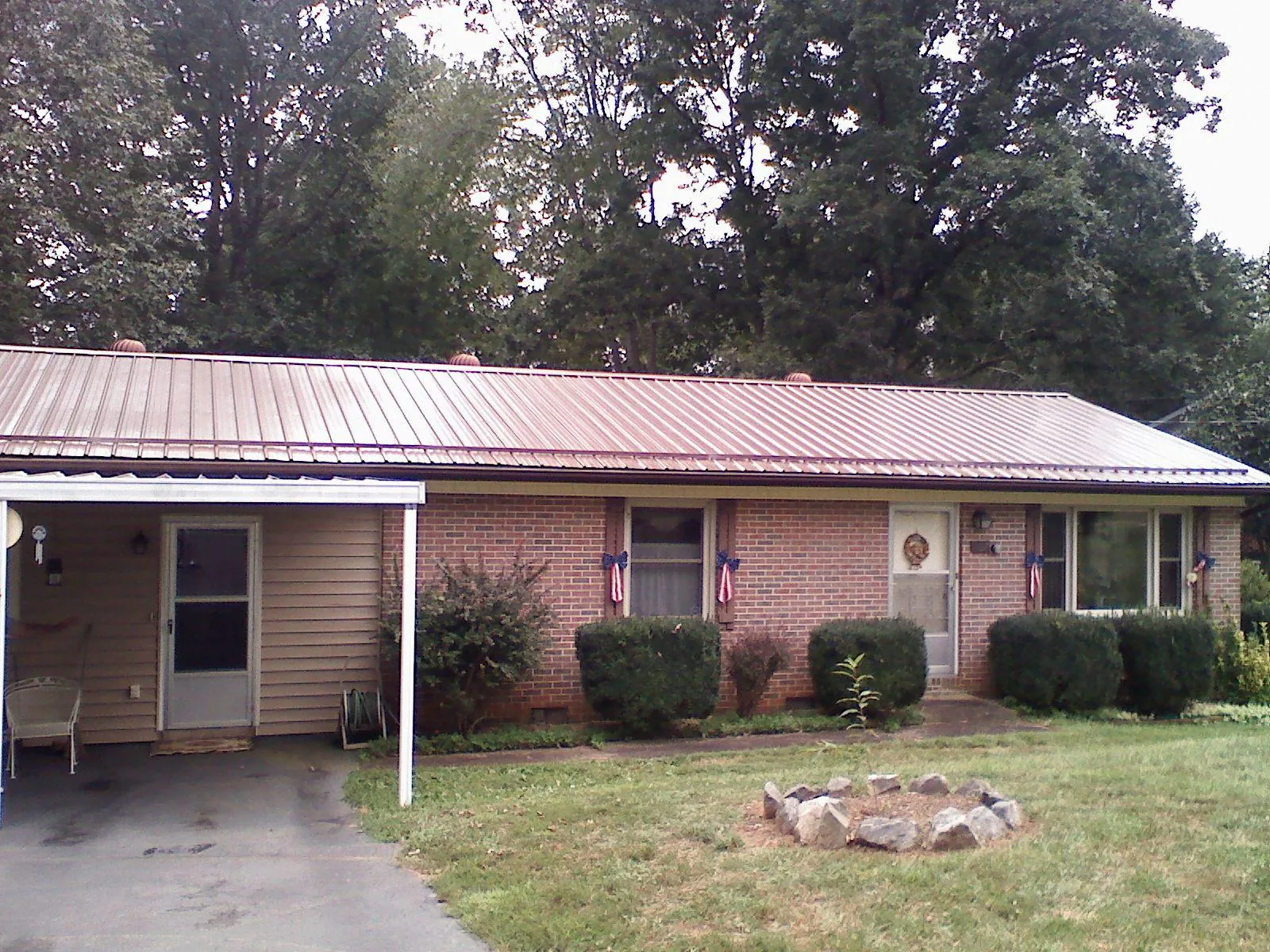 Bronze metal roof and carport on a brick ranch home — Roof Repair work by our crew in Crawford